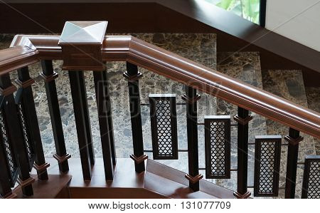 Elegant stairs with handrail decorated by stone and wood in the house.