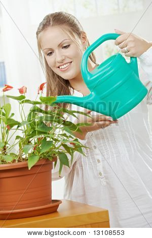 Happy young Woman Bewässerung Anlage mit Beregnung kann lächelnd.