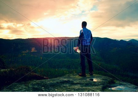 Sweaty Tall Hiker In Cyan Trikot With Bottle Of Water. Adult Tired Tourist On The Peak Of Rock Watch
