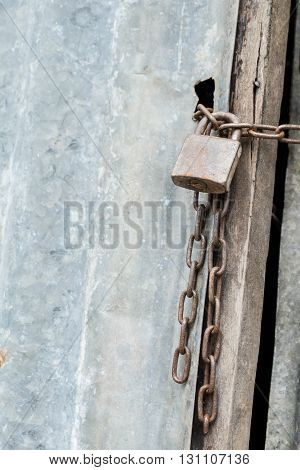 An old lock and chain on a rusty door