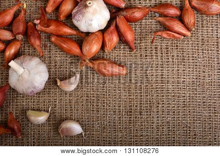 Background with garlic. Garlic on burlap. Slice garlic. Vegetables. Frame of garlic cloves.