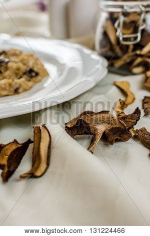 Dry mushrooms and traditional italian risotto on white plate