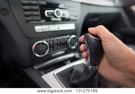 Driver shifting the gear stick in car