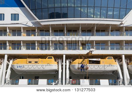 Copenhagen, Denmark - May 02, 2016: A man working on the lifeboats of the Cruise ship AIDAluna.