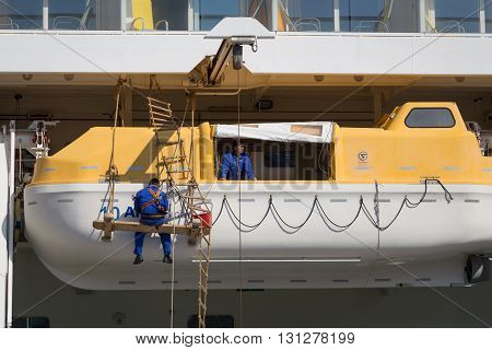 Copenhagen, Denmark - May 02, 2016: Men working on the lifeboats of the Cruise ship AIDAluna.
