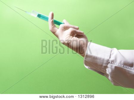 Spritze in Händen auf grün