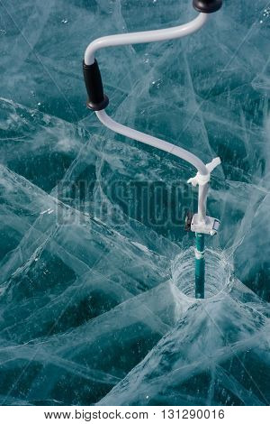 Ice ax - ice screws on winter fishing on the ice caves. Ice is very clean and beautiful. The Lake Baikal.