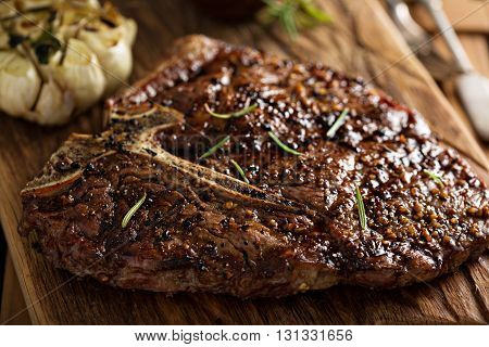 Tbone beef steak cooked on a grill with rosemary and garlic