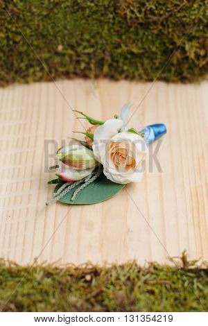 Beauty of colored flowers. Bridal accessories. Close-up bunch of florets. Details for marriage and for married couple. Wedding bonbonniere for the groom on wooden background