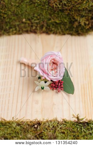 Beauty of colored flowers. Bridal accessories. Close-up bunch of florets. Details for marriage and for married couple. Wedding bonbonniere for the groom on wooden background