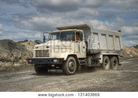 Poltava Region Ukraine - June 26 2010: Dump truck driving along the opencast road with mud