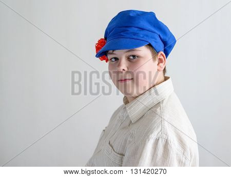 Portrait of a boy teenager in Russian national cap with cloves