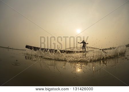 Asian Fisherman action on the boat fishingnet.