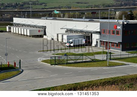 Dolny Hricov Slovakia - April 13 2016: Modern logistics center of international parcel delivery company DPD white van and trailers standing on ramp