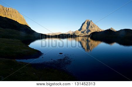 Midi Dossau Peak reflected in Gentau lake. Ossau Valley, Pyrenees National Park, Pyrenees, France.