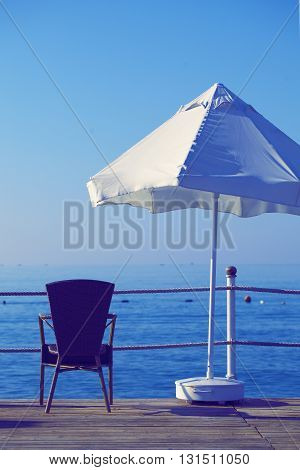 Umbrela and armchair at the sea. Vacation background