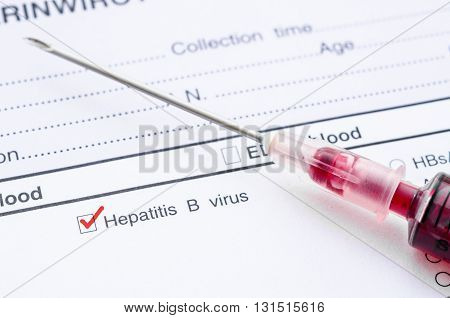 Red mark on Hepatitis B screening test form with blood sample in syringe.