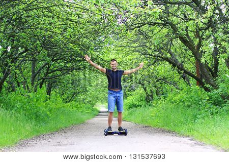 young fit man riding an electrical scooter outdoor - portable personal eco transport, gyro scooter, gyroboard, smart balance wheel, hoverboard