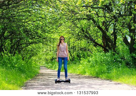 young woman riding electrical scooter outdoor - personal eco transport, hoverboard, gyro scooter, hyroscooter, smart balance wheel