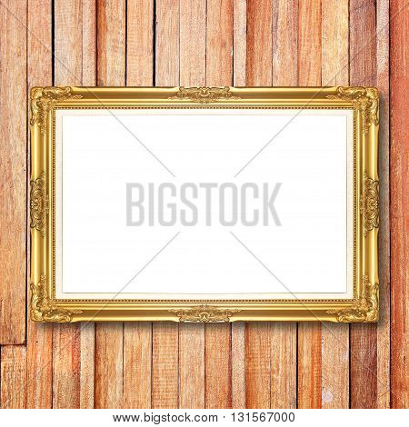 Antique gold frame on wooden wall;. Empty picture frame on wooden wall.