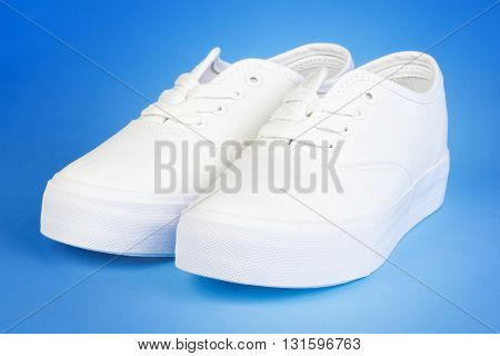 Flatform Plimsolls in white on blue .