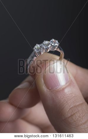 Choosing  diamonds rings, holding it with te fingers