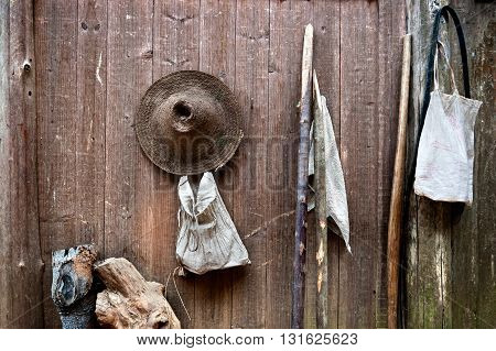 WOOD WALL WITH STRAW HAT AND STICKS