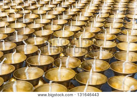 Close up photo of many candles in a buddhist temple
