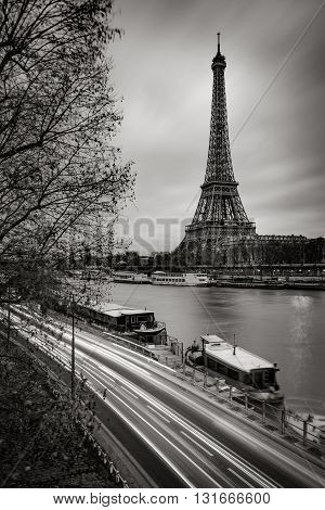 The Eiffel Tower and Seine River in early morning with clouds and car light trails in Black & White. Paris, France