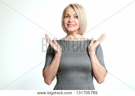 Surprised happy woman looking sideways in excitement. Isolated over white background. Portrait of happy aged woman.