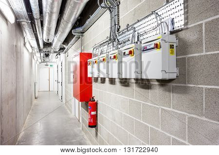 there are several pipes and a fire extinguisher in the basement