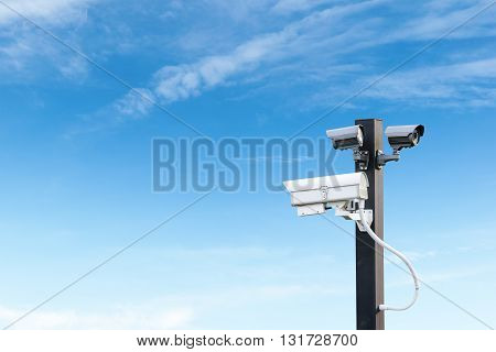 Security cctv surveillance camera over  blue sky with copy space