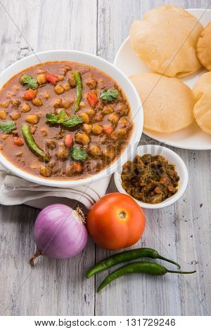 indian dish spicy Chick Peas also known as Chola Masala or Chana Masala or Chole served in a white bowl, isolated