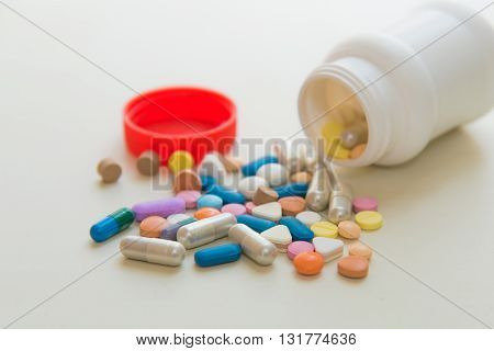 Close up of various medicine pills on white table.