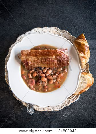 Cooked beans with ribs on rustic background