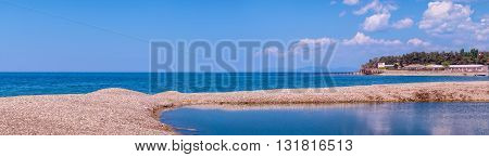 Seashore summer panorama with horizon blue sky