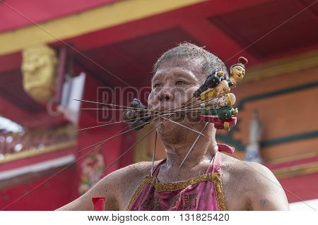 PHUKET THAILAND - OCT 18 2015: Chinese thai monk possessed by his god walks with his mouth pierced in Vegetarian Festival at Phuket Town. Festival is a famous annual also known as Nine Emperor Gods