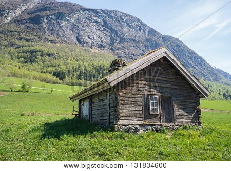 Norwegian mountain cabins of wood with grassy rooftops surrounded by stunning nature..