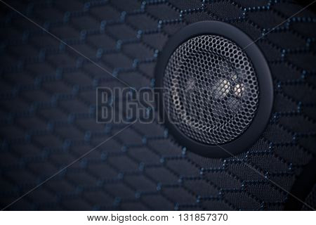 Close up shot of a round speaker in a car.