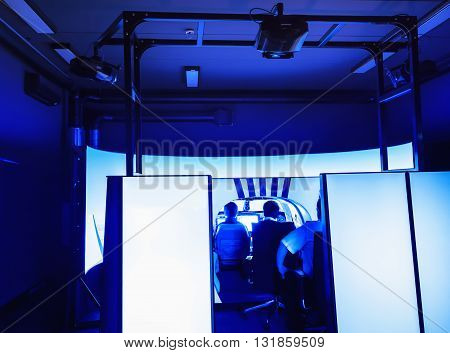 Room with an installed flight simulator for small private airplanes blue colored. General view of the cabin.