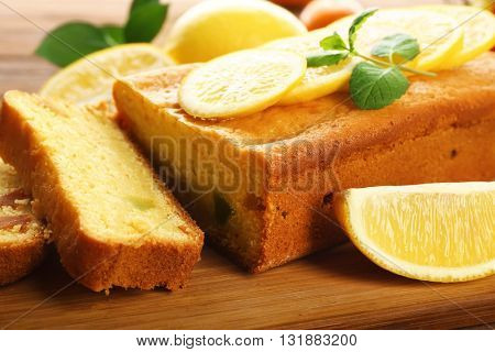 Delicious citrus cake loaf with lemons on wooden board