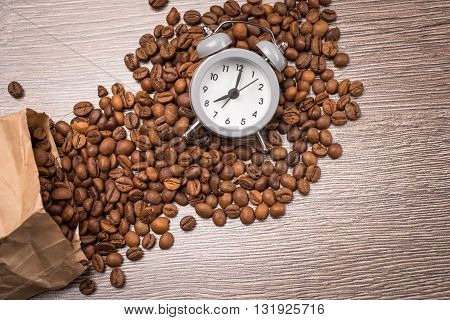 vintage alarm clock and coffee beans on wooden table