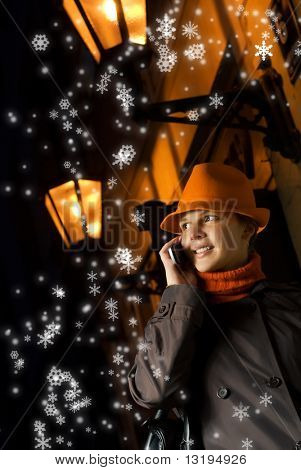 Conversaciones de la hermosa chica en el teléfono en la noche de Navidad