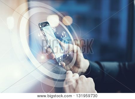 Photo businessman relaxing modern loft office. Man sitting in chair at night.Using contemporary smartphone. Digital Connections World Wide Interfaces Screen. Horizontal, film effect, blurred background