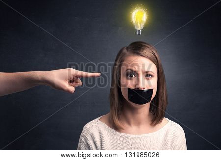 Caucasian hand pointing at female employee with a lightbulb above her head