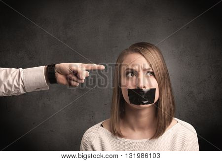 Caucasian business hand pointing at female employee with grunge background