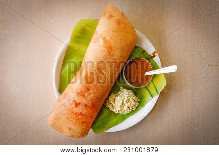 Traditional Southern Indian rice Dosa on banana leaf.