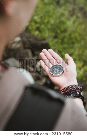 Women Looked At The Compass In Her Hand To Find Right Direction.