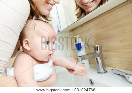 Mother Wahing Baby Hand . Child Get Accustom For Cleanness. Mom And Son Having Fun Together In Bathr