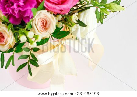 Composition Of Flowers In A Pink Hatbox. Tied With Wide White Ribbon And Bow.